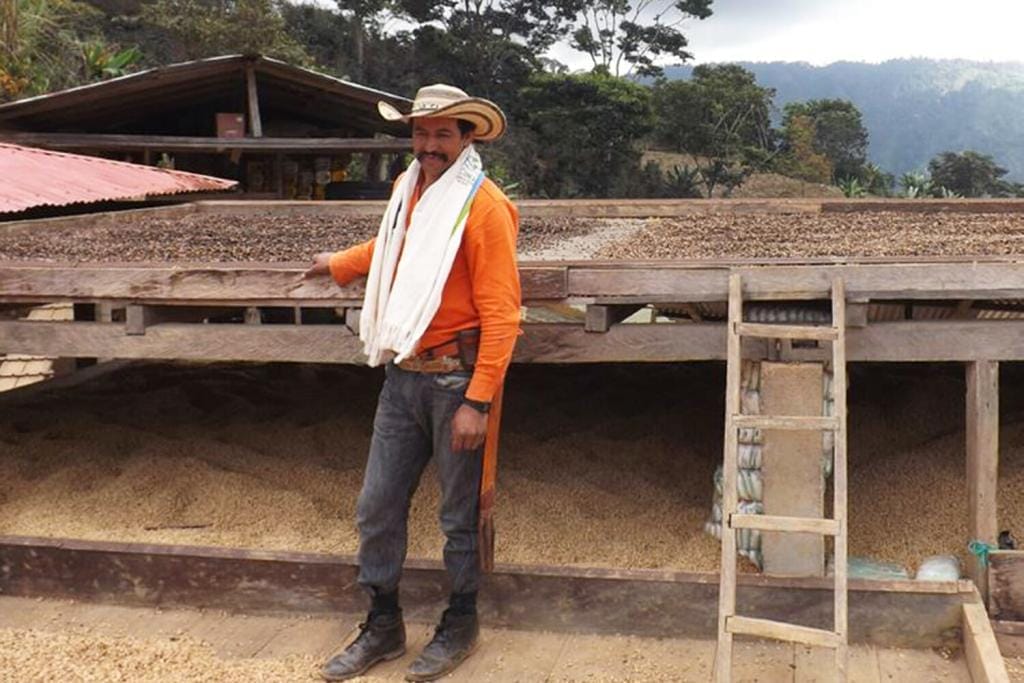 Colombia Sierra Nevada Sol Naciente producer standing alongside his specialty coffee