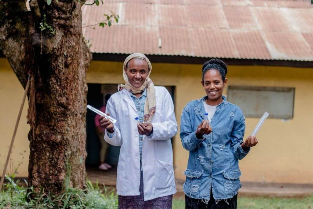 two women in coffee with HPV self-sampling kits