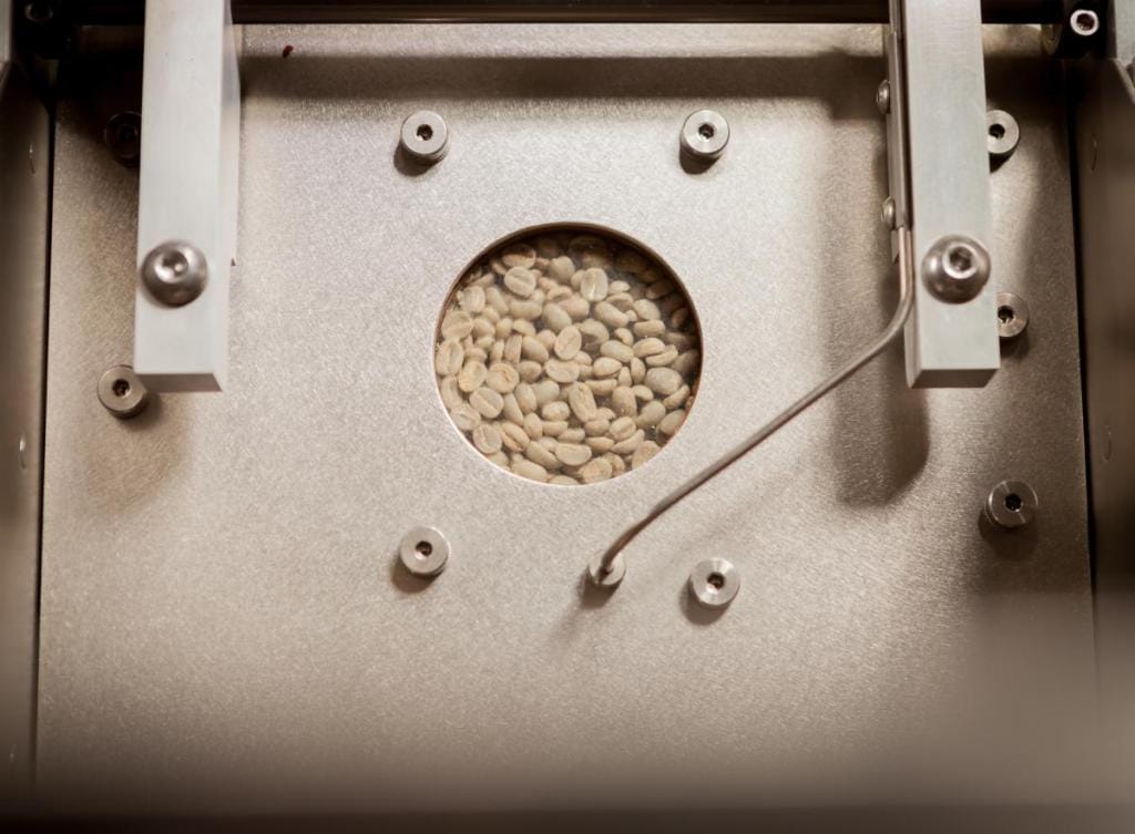 Green coffee being roasted in a Loring coffee roaster at the Royal New York Lab showcasing one of the coffee roasting phases