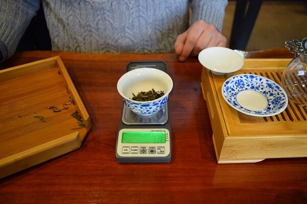 puer tea being weighed on a scale before it is  brewed gongfu style